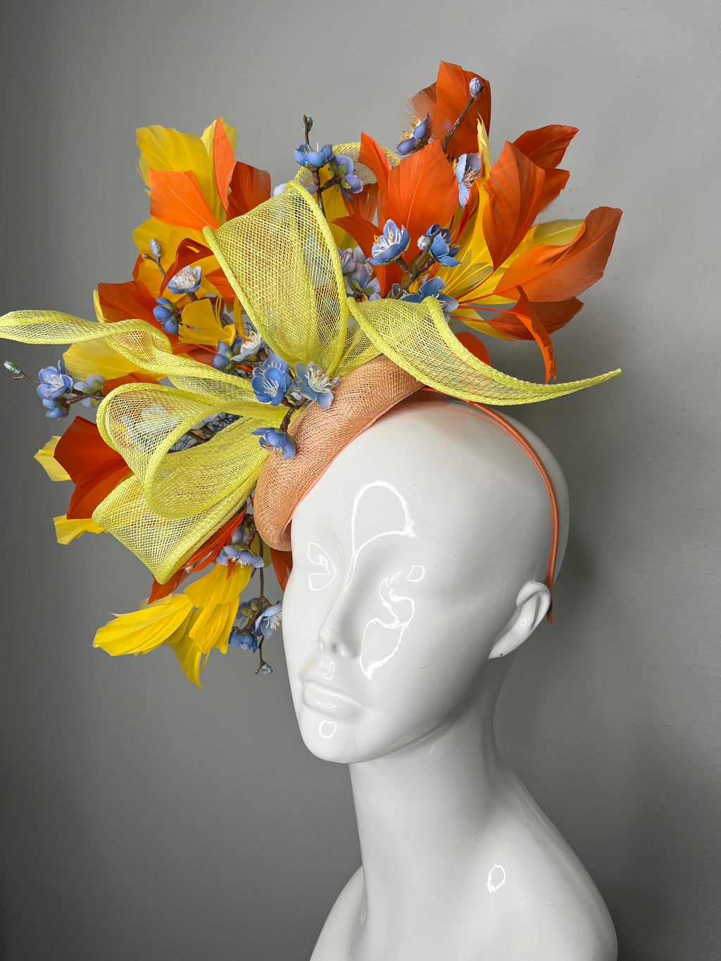 Gelbe und orangefarbene Sonnenschein-Serenade mit blauem Blumen-Faszinator-Hut
