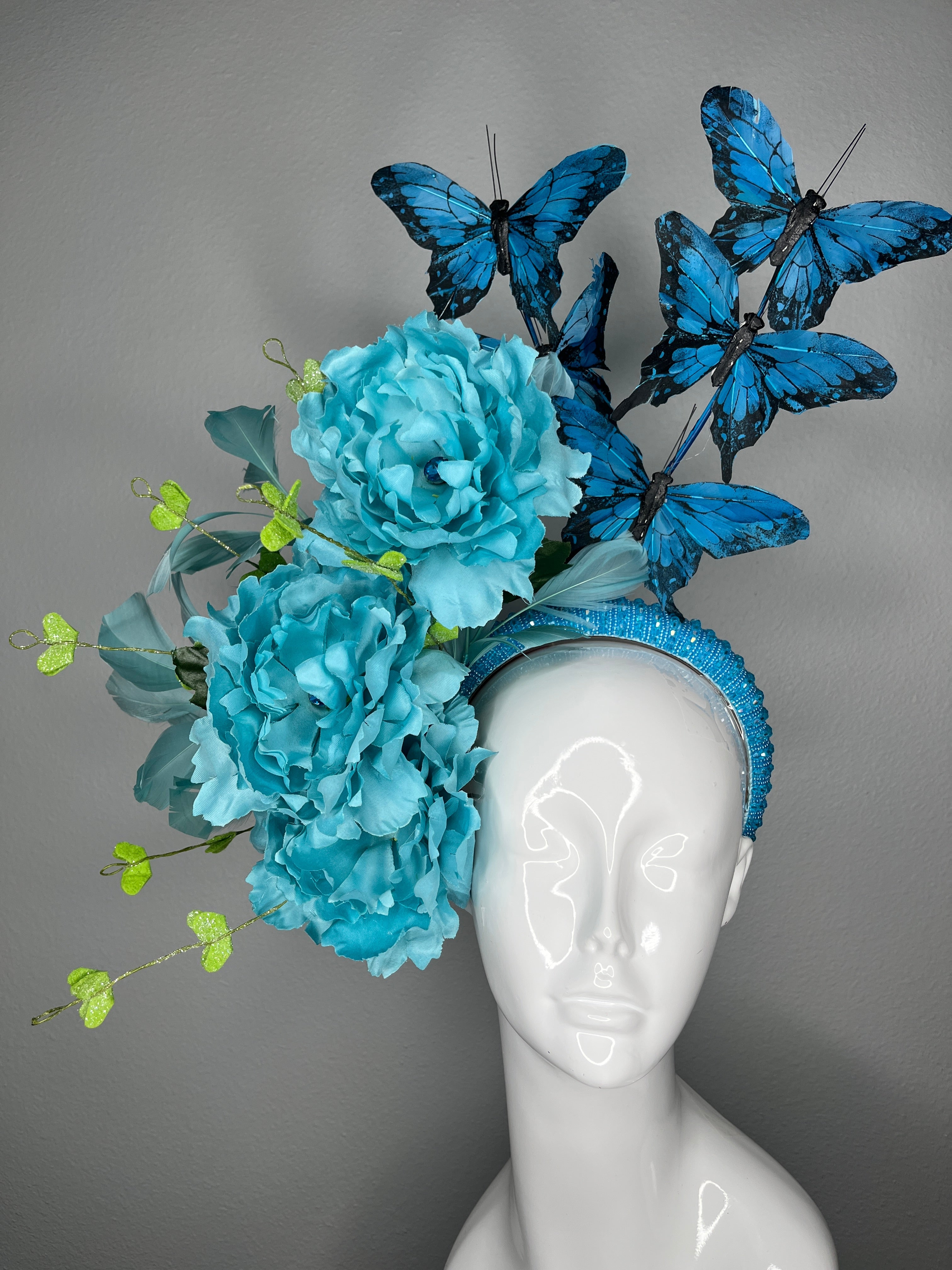 Türkisfarbene Blumen Schmetterling Fascinator-Haarreif Statement Derby-Hut mit blauen Schmetterlingen übergroße Blüten
