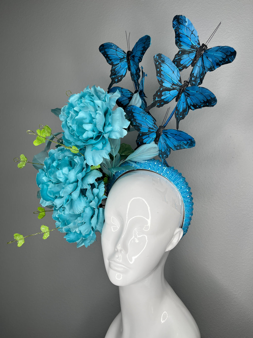 Türkisfarbene Blumen Schmetterling Fascinator-Haarreif Statement Derby-Hut mit blauen Schmetterlingen übergroße Blüten